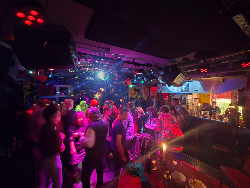 Die Raumstation beim Tanztreffen. Menschen Tanzen auf der Tanzfläche, Diskobeleuchtung.